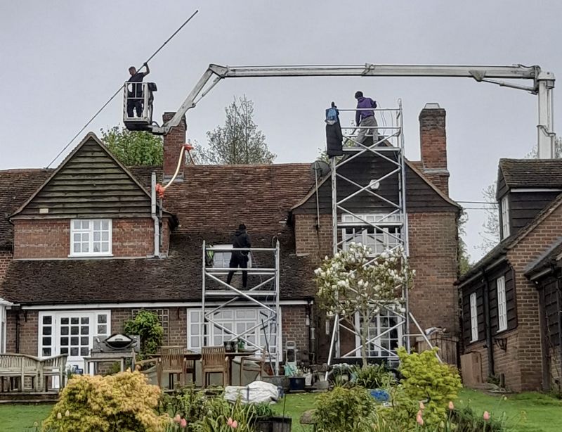 The Moss Cleaners using cherry picker and scaffolding to clean roof safely and professionally in Amesbury, Wiltshire